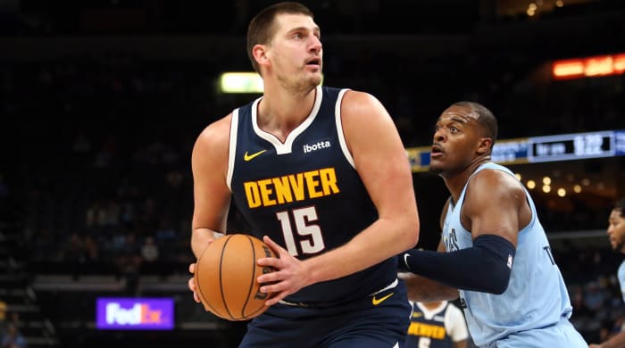 Denver Nuggets center Nikola Jokic spins toward the basket as Memphis Grizzlies forward Xavier Tillman defends.